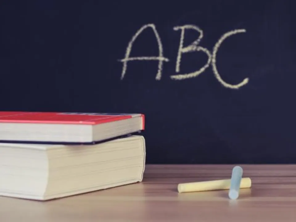 تخته‌سیاه با حروف ABC و کتاب‌های روی میز